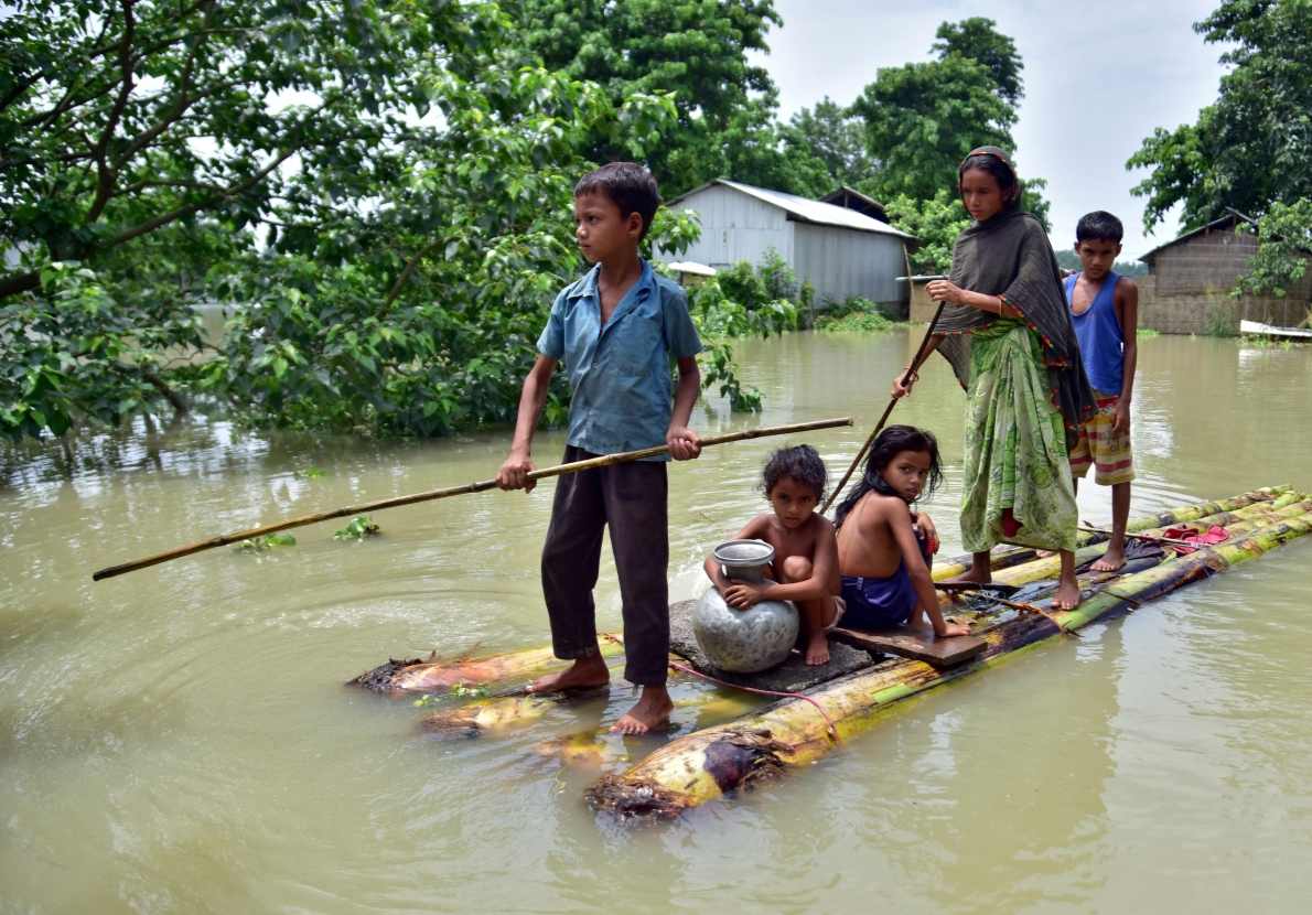 A family in Assam standing together outside their home